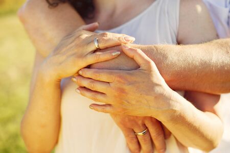 Aduld couple in a summer field. Handsome senior in a white shirt. Woman in a white dressの写真素材
