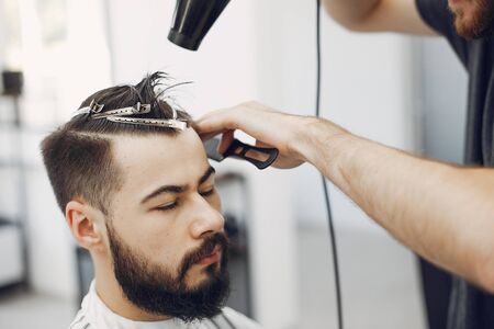 Stylish man sitting in a barbershopの写真素材