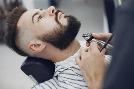 Man with a beard. Hairdresser with a client. Brunette in a barbershopの写真素材