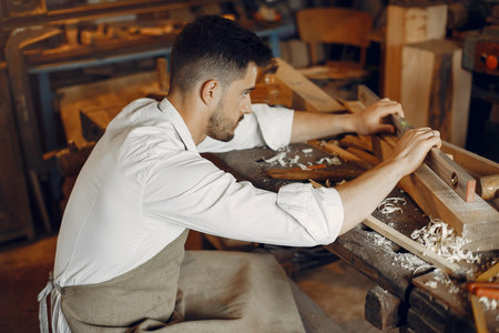 Handsome carpenter working with a wood
