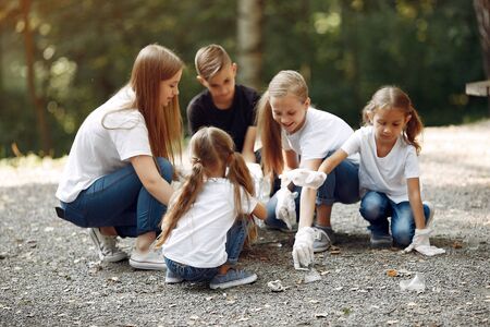 Children collects garbage in garbage bags in parkの写真素材