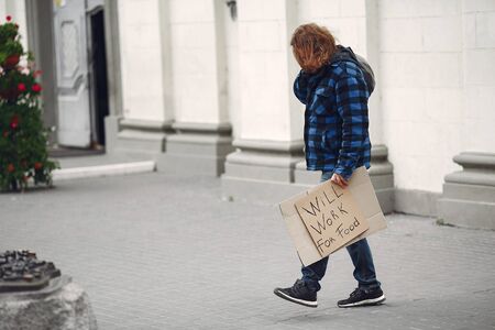 Homeless man in a durty clothes autumn cityの写真素材