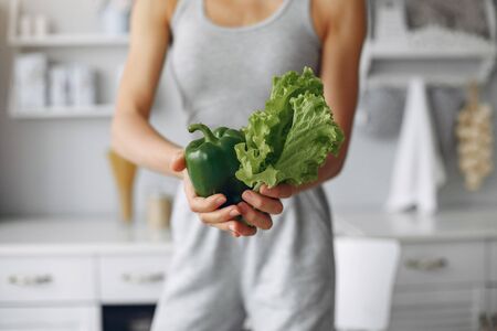 Healthy eating. Dieting and people concept. Brunette with a vegetable.の写真素材
