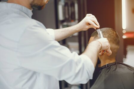 A man cuts hair in a barbershopの写真素材
