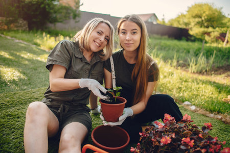 Mother with a daughter works in a garden near the house