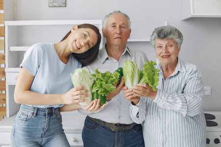 Old couple in a kitchen with young granddaughter