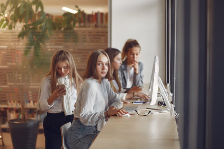 Three students sitting at the table in a classの写真素材