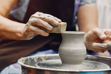 Grandmother with a grandchildren make pitchers in potteryの写真素材