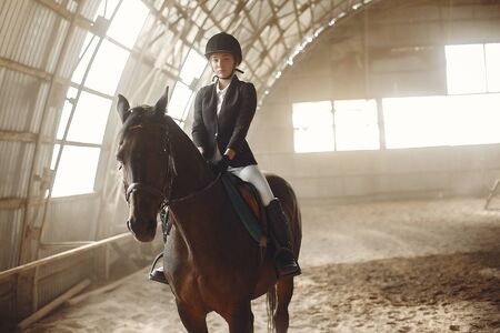 The rider in black form trains with the horseの写真素材