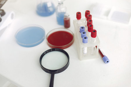 Coronavirus testing samples with bottles solutions inside and a loupe on a table