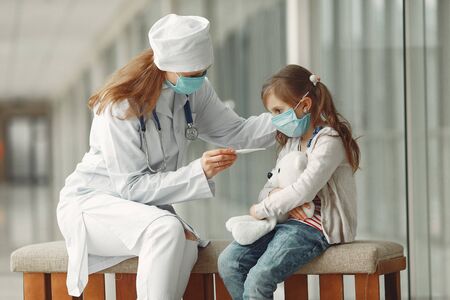 Doctor and a child in protective masks are in hospitalの写真素材