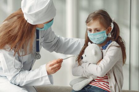 Doctor and a child in protective masks are in hospitalの写真素材