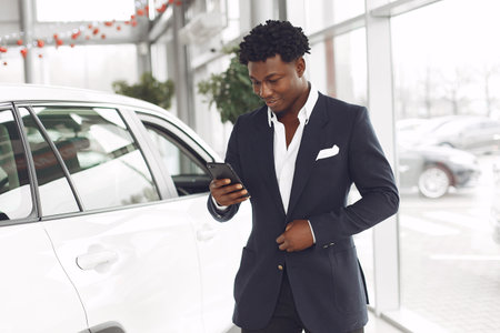 Handsome and elegant black man in a car salonの写真素材