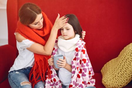 Mother gives her sick daughter hot teaの写真素材