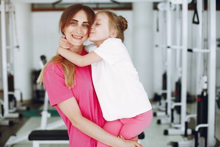 Mother with little daughter are engaged in gymnastics in the gymの写真素材