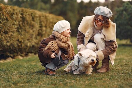 Mother with daughter walks with a dogの写真素材