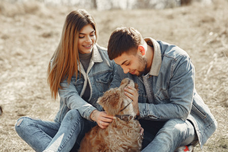 Cute couple in a jeans clothes in a spring fieldの写真素材