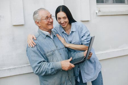 Girl teaching her grandfather how to use a laptopの写真素材