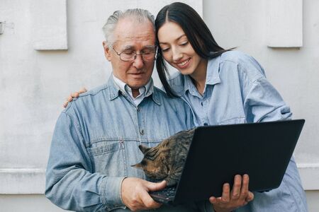 Girl teaching her grandfather how to use a laptopの写真素材