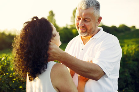 Beautiful adult couple spend time in a summer field
