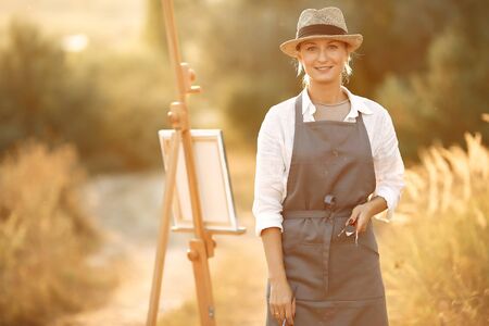 Woman in a apron painting in a fieldの写真素材