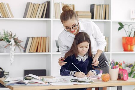 Tutor with litthe girl studying at homeの写真素材
