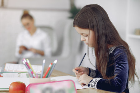 Little girl sitting on a table with books