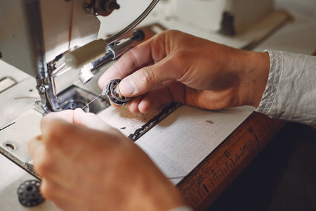 Man working with leather. Professional makes a wallet. Man uses a sewing mashine.