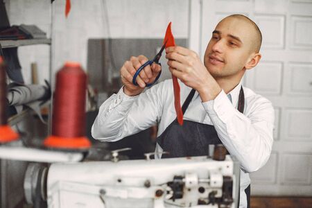 Man in a studio creates leather wareの写真素材