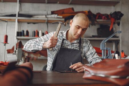 Man in a studio creates leather wareの写真素材