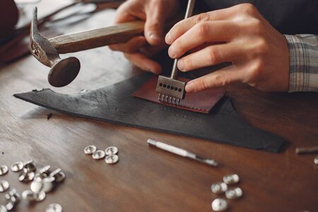 Man in a studio creates leather wareの写真素材