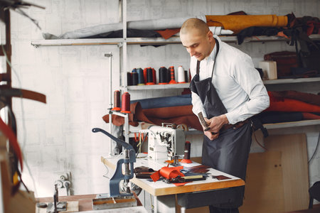 Man in a studio creates leather ware