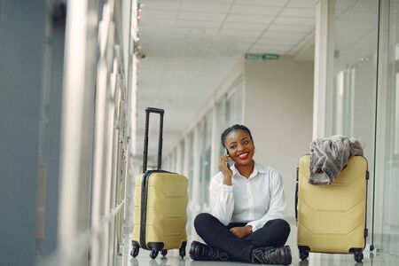Black woman with suitcase at the airportの写真素材
