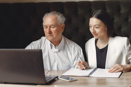 Two business partners working with a laptop in a cafe