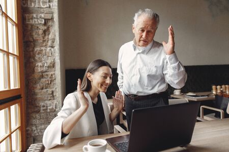 Two business partners working with a laptop in a cafe