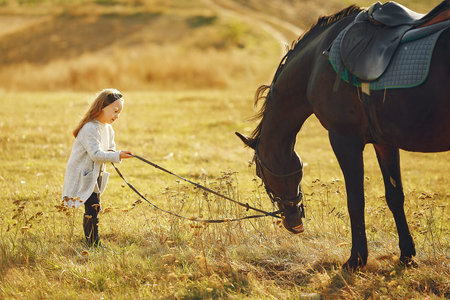 Child with a horse. Little girl in a autumn park.の写真素材