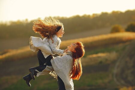 Family in a autumn field. Mother with red hair. Cute little girlの写真素材