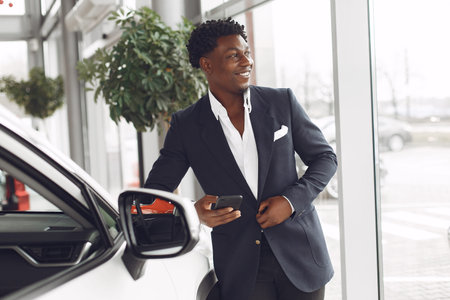 Handsome and elegant black man in a car salon