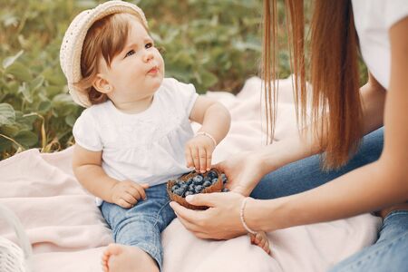 Mother with daughter playing in a summer fieldの写真素材