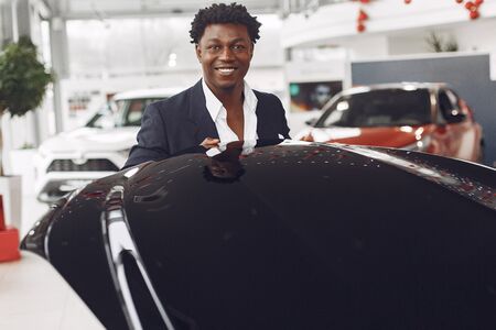 Handsome and elegant black man in a car salonの写真素材