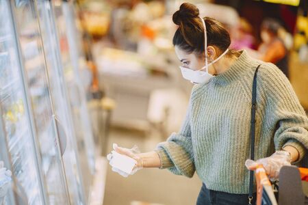 Woman in a respirator in a supermarketの写真素材