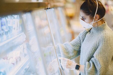 Woman in a respirator in a supermarketの写真素材