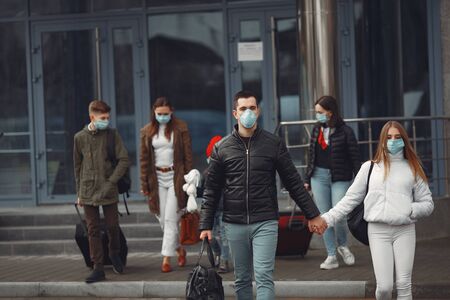 Travelers leaving airport are wearing protective masksの写真素材