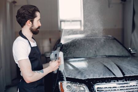 Man washing his car in a garageの写真素材