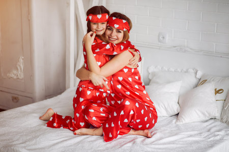 Cute mother and daughter at home in a pajamasの写真素材