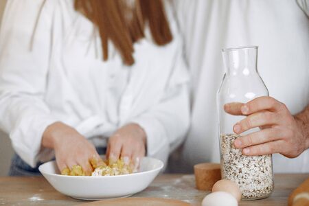 Couple in a kitchen. Blonde in a white shirt. Woman with her boyfriendの写真素材