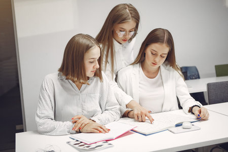 Three students sitting at the table in a class