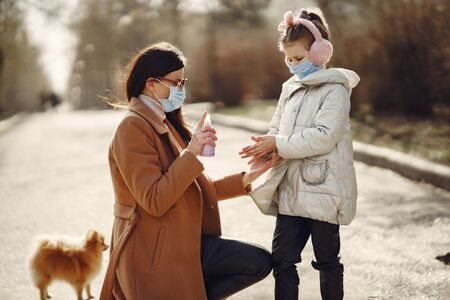 Mother with daughter walks outside in masksの写真素材