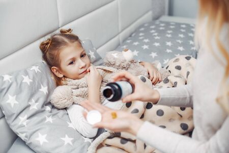 Mother with her illnes daughter in a bedroomの写真素材