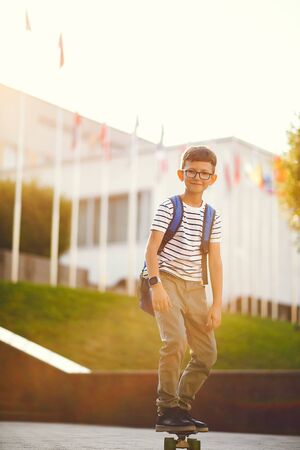 Schoolboy with a skate and backpackの写真素材